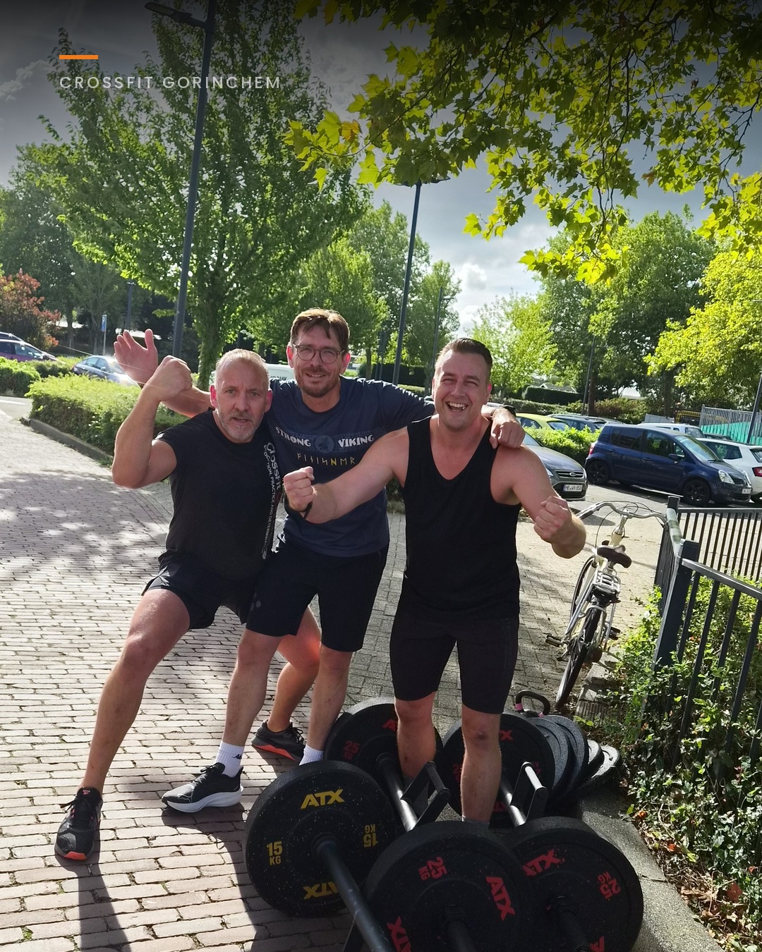 Bootcampdeelnemers lopen met gewichten over een laan tijdens een buitentraining