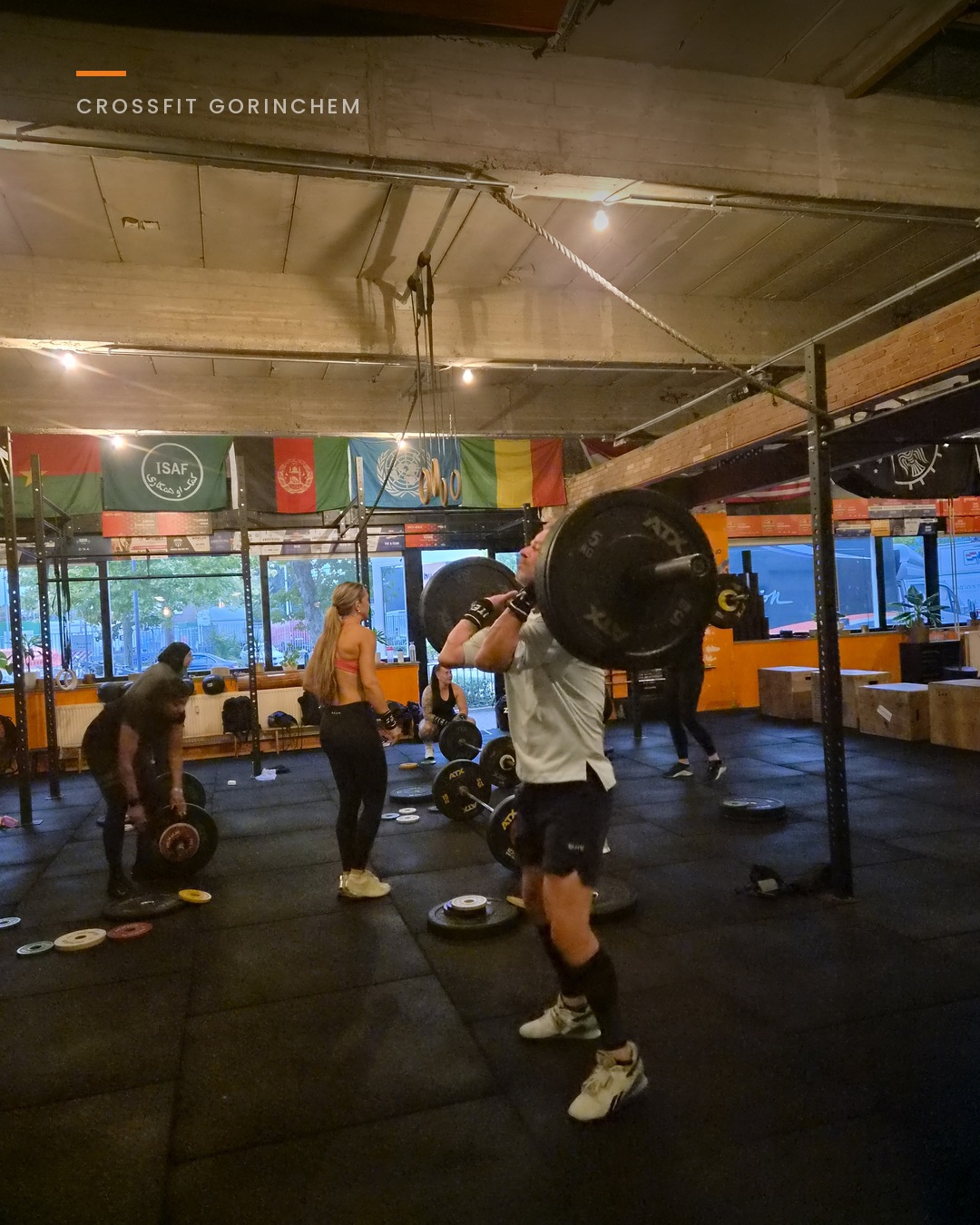 CrossFit-les met barbells, meerdere leden tegelijk aan het werk