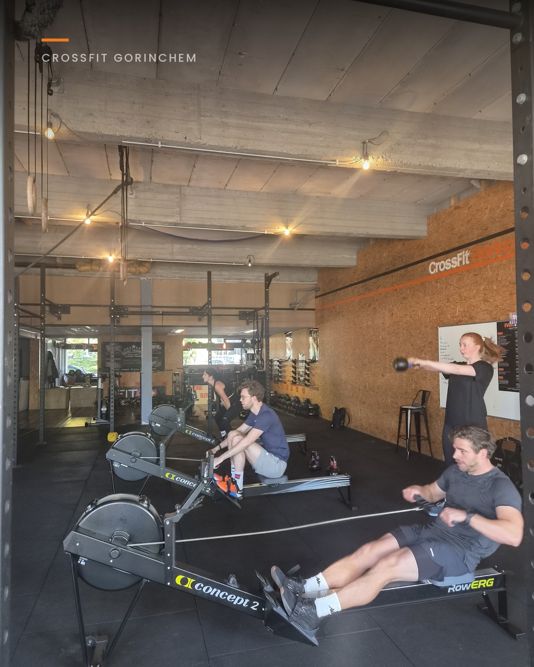 Training met roeien en kettlebells, gezien door het rek met gewichten