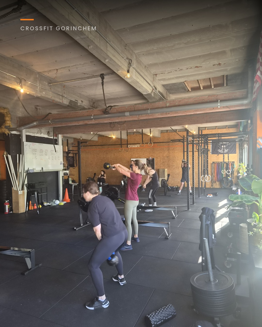 Groep traint kettlebell swings, de kracht komt uit de heup